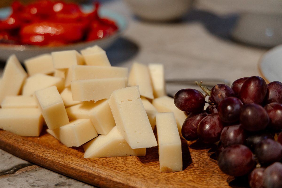 Käse und Trauben auf einem Holzbrett
